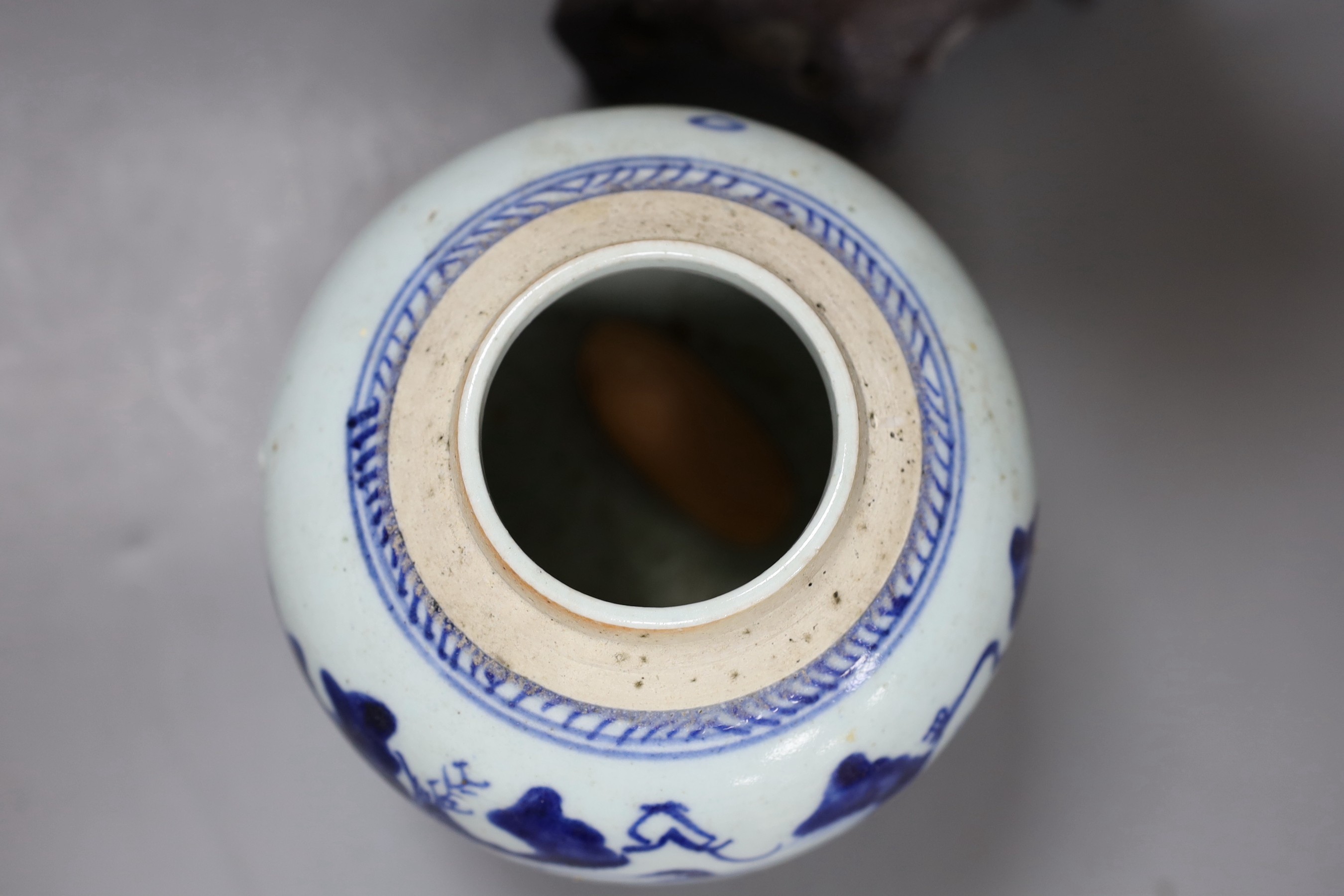 A Chinese soapstone carving of a deity and a similar early 19th century blue and white jar, tallest 30cm